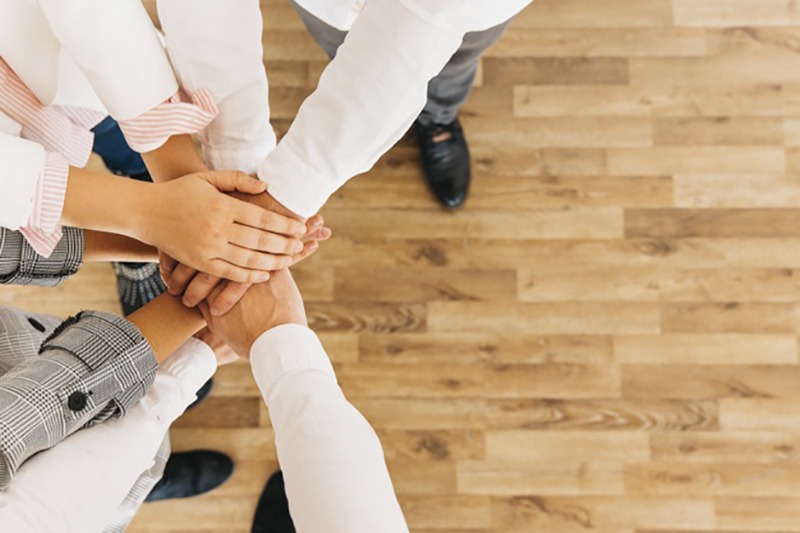 Pessoas juntando as mãos em trabalho em equipe