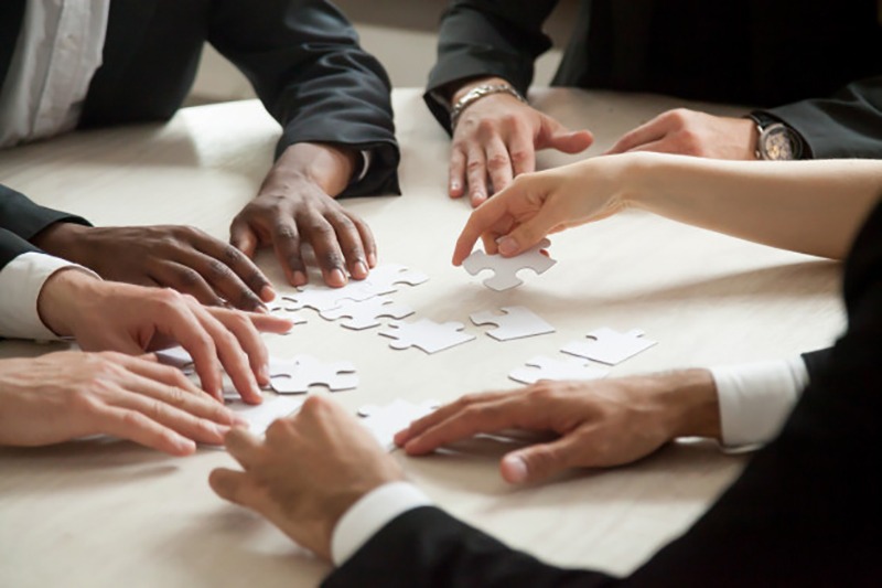 Empreendedores montando um quebra-cabeças em branco