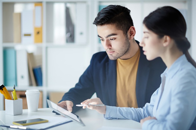 Dois empreendedores trabalhando juntos usando um tablet